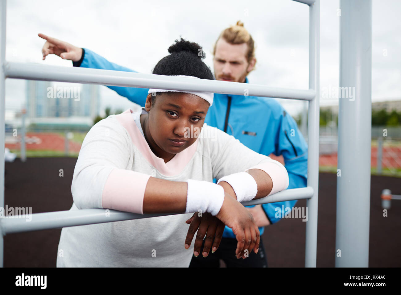 Ritratto di stanchi chubby donna appoggiata sul pull-up bar Foto Stock