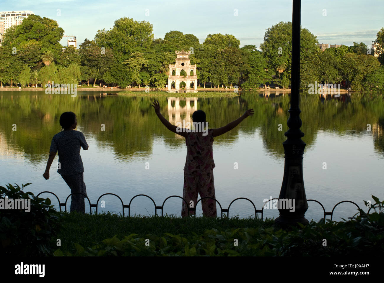 Thap rua tempio o torre di tartaruga lago Hoan Kiem hanoi vietnam. facendo ginnastica mattutina a Hoan Kiem accanto a thap rua (tartaruga torre). hanoi vecchio quart Foto Stock