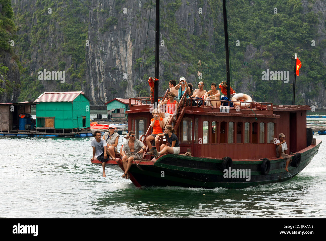 I turisti in giunca Cinese, baia di Halong imbarcazione turistica tour, Vietnam. Posta indesiderata, in barca a vela tra Carso montagne calcaree a cat ba national park, ha long Foto Stock