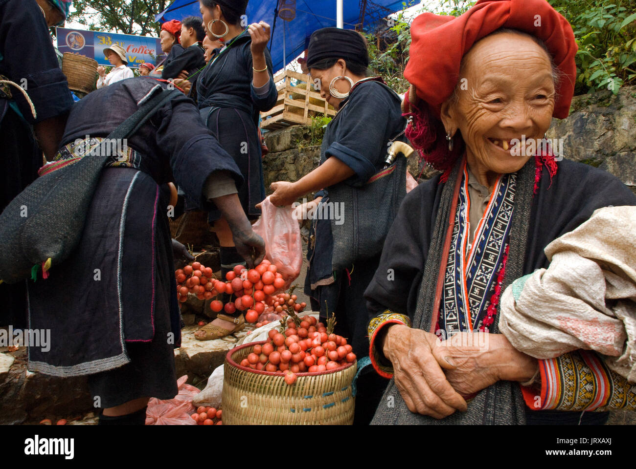 Le donne dal rosso dao hmong gruppo etnico la vendita di frutta e verdura fresche a bac ha mercato, sapa regione, lao cai provincia, Vietnam Foto Stock