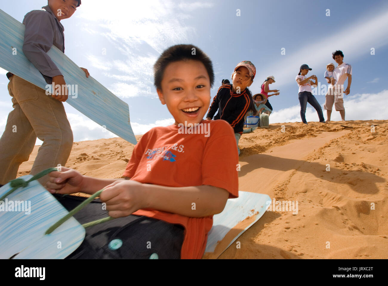 I giovani hanno funthrowing stessi attraverso il deserto di sabbia a le bianche dune di sabbia, Mui Ne, Vietnam. Foto Stock