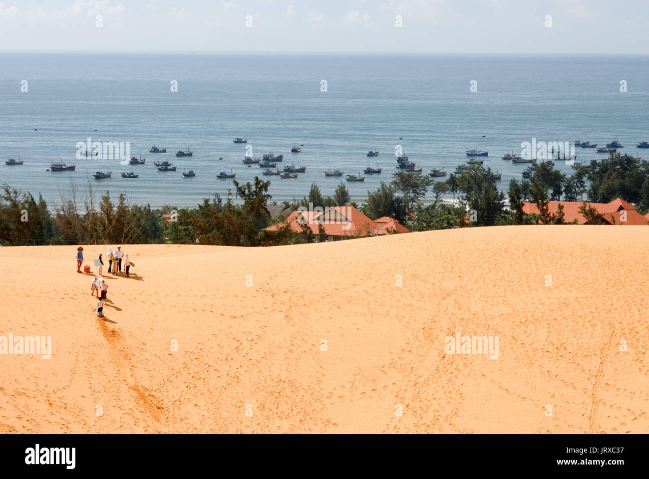 I giovani hanno funthrowing stessi attraverso il deserto di sabbia a le bianche dune di sabbia, Mui Ne, Vietnam. Foto Stock