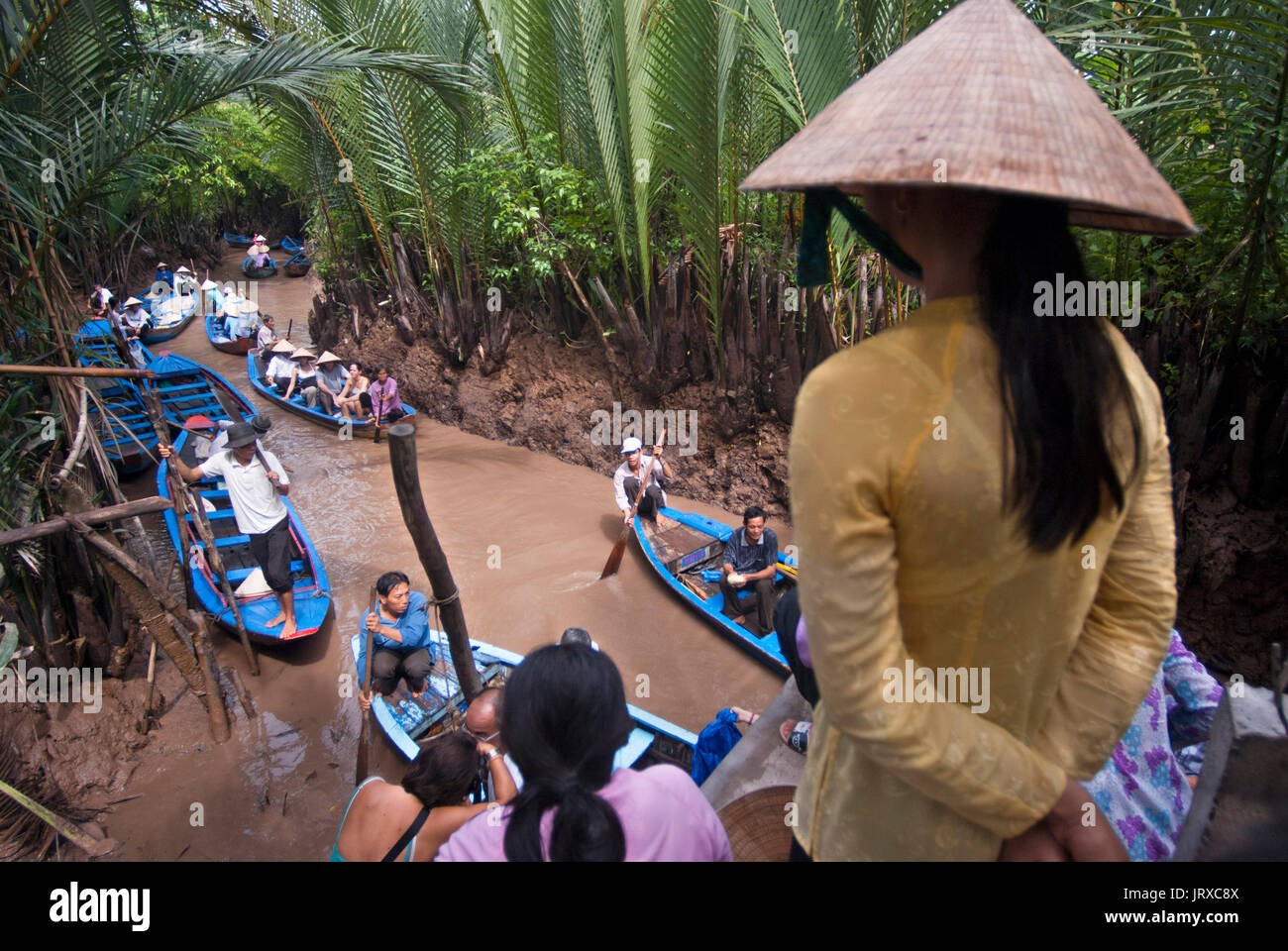 Donna e barche a remi sul fiume Mekong, vicino a My Tho village, Vietnam. Bao Dinh canale, delta del Mekong. La donna a non conica hat canottaggio una piccola barca su Foto Stock