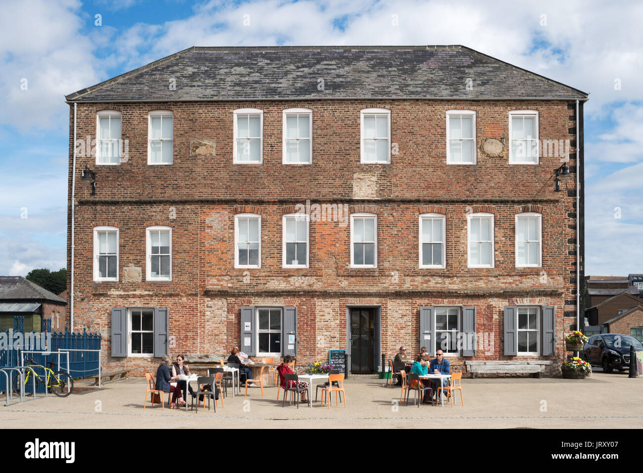 La gente seduta al di fuori del Vecchio luce bassa Heritage Centre, North Shields, England, Regno Unito Foto Stock