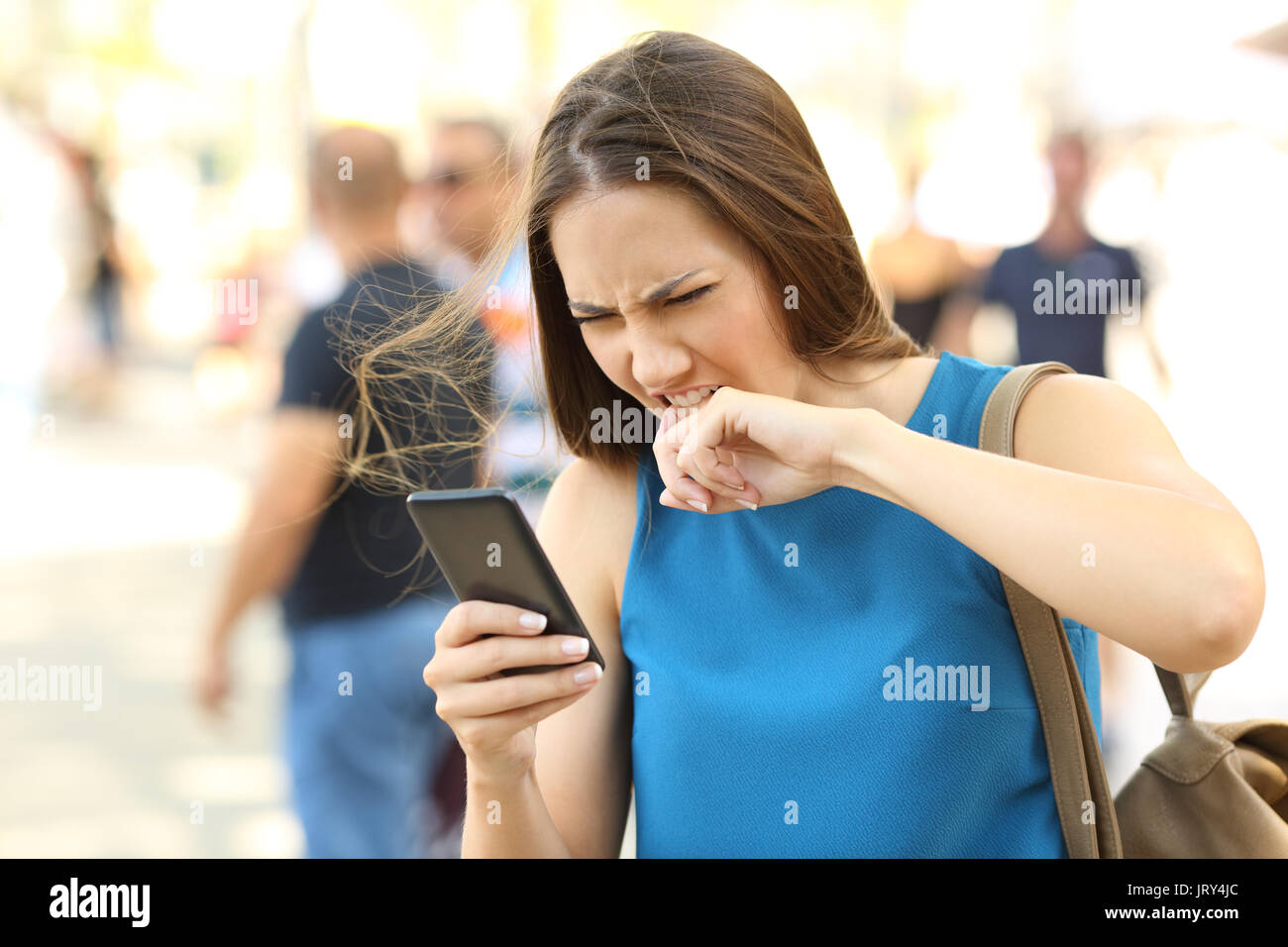 Arrabbiato donna stufi del suo cellulare sulla strada Foto Stock