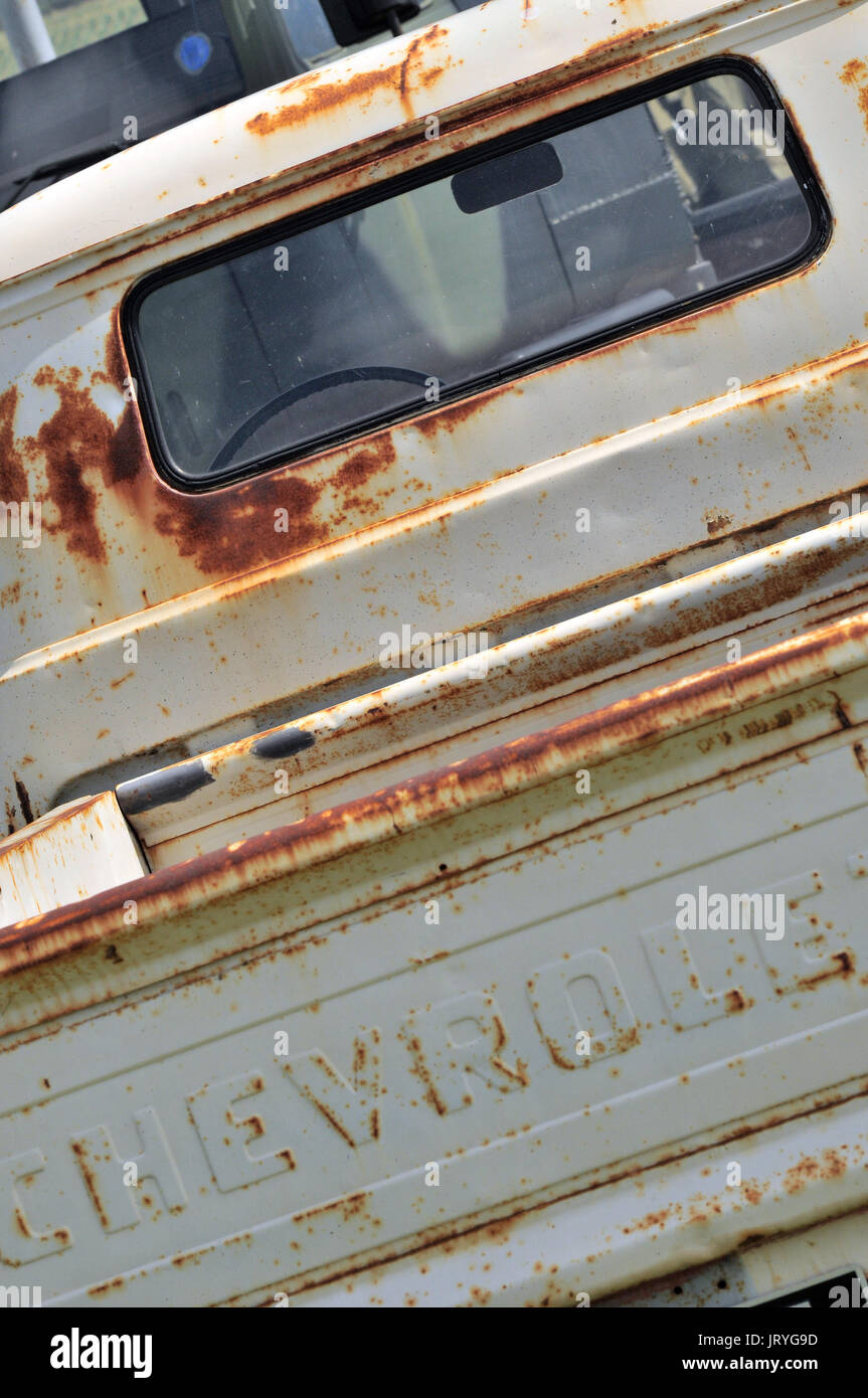 Un vecchio Chevrolet pick up truck hanno bisogno di qualche intervento di restauro e coperto di ruggine con usurati vernice sbiadita e trasandato progetto carrozzeria per teste di benzina Foto Stock