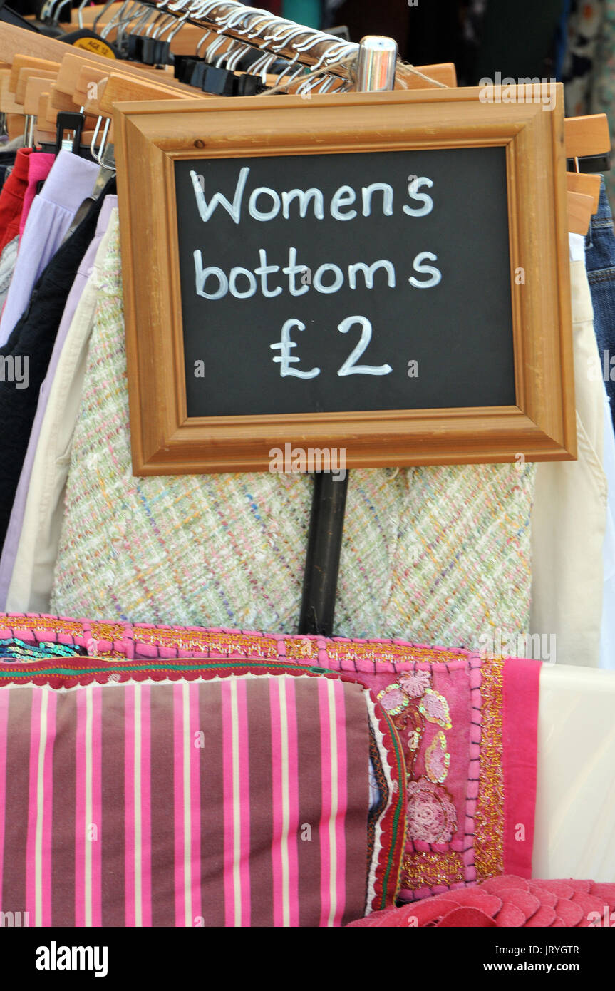 Un divertente segno su un abbigliamento stallo a un mercato all'aperto dicendo "donne fondi dell' £2 o due libbre. lingua in guancia commenti umoristici e pubblicità. Foto Stock