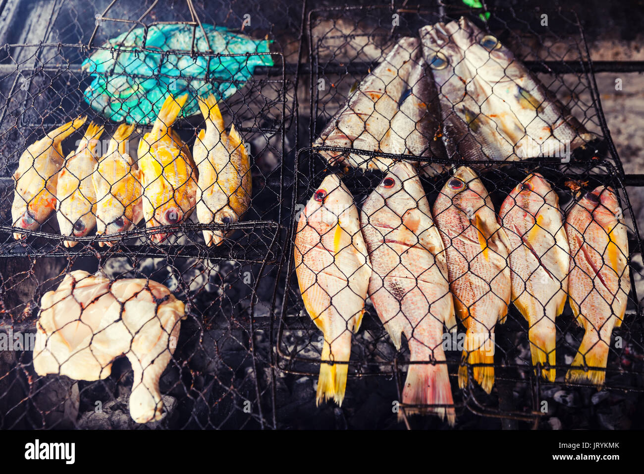 Pesce fresco alla griglia: pesci pappagallo, polpo, gamberi sfondo alimentare barbecue. La cottura barbecue di pesce sul fuoco Foto Stock