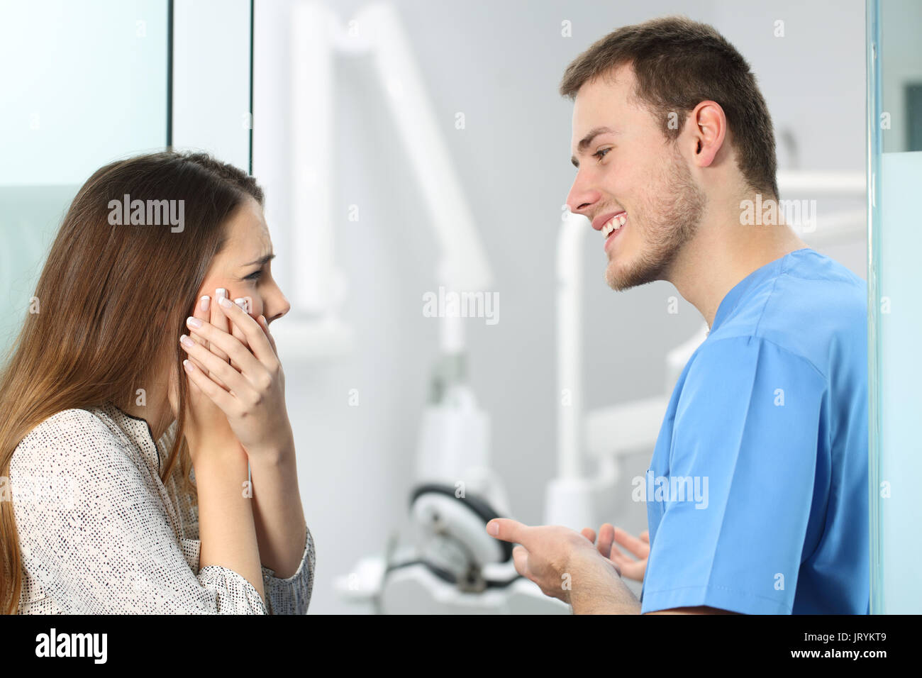 Dentista la ricezione di un paziente che soffre di mal di denti e lamenta Foto Stock