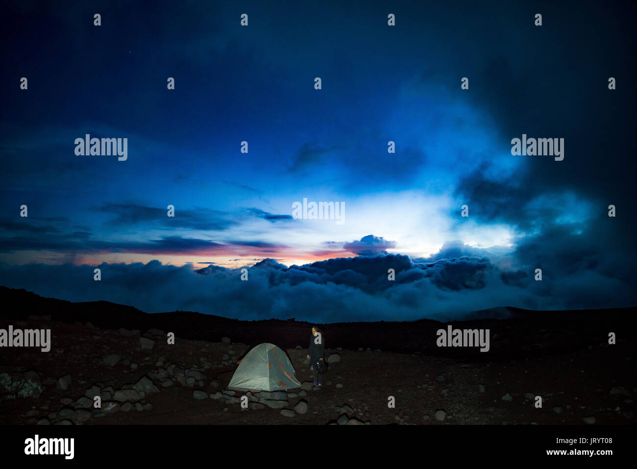 Una giovane donna campeggio a 16.000 piedi sopra il livello del mare sul Monte Chimborazo il picco più alto in Ecuador. Foto Stock