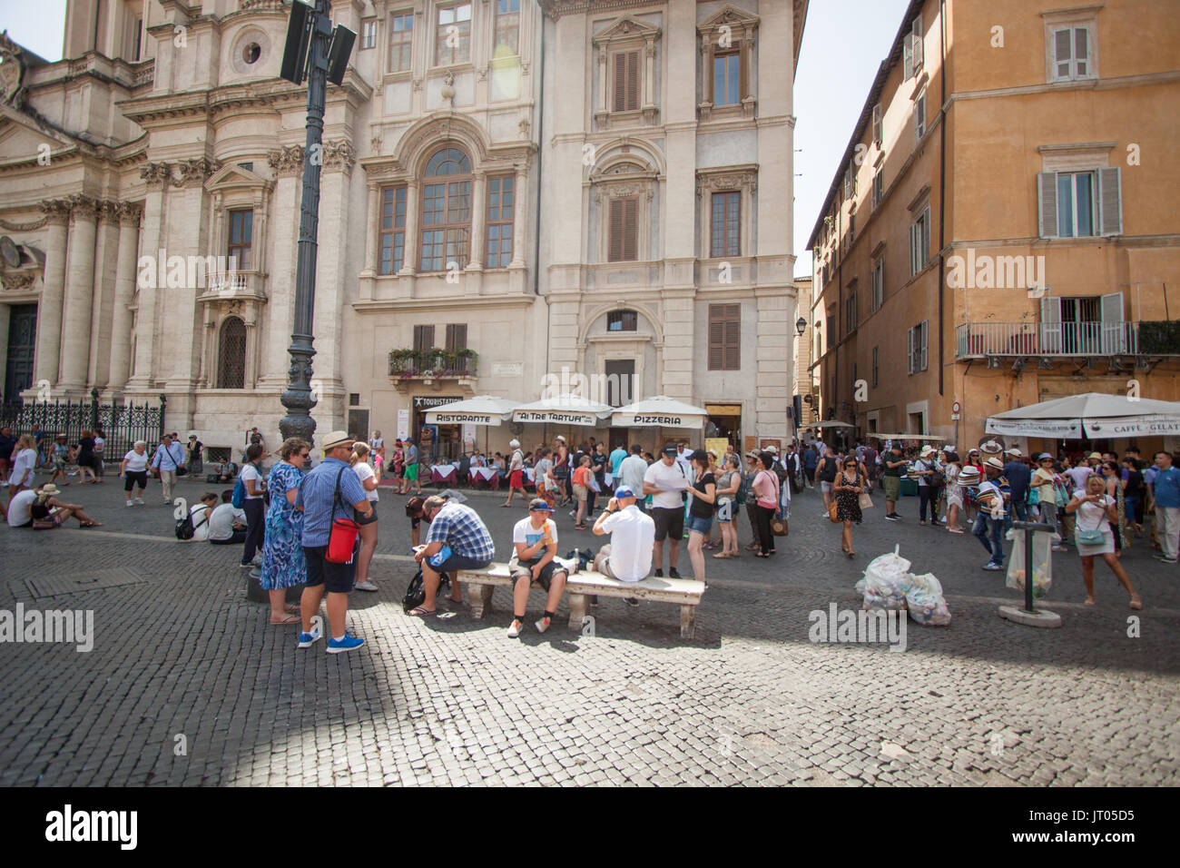 Prendendo uno sfiatatoio: Visitatori immergetevi nell'atmosfera sulla Piazza Navona, Roma Italia Foto Stock