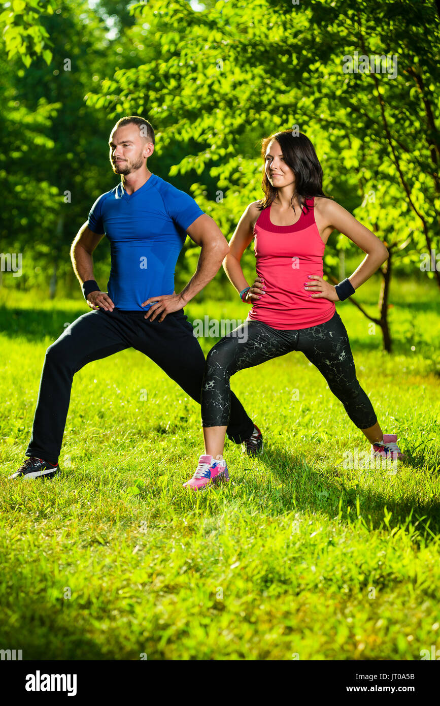 L uomo e la donna a fare esercizi di stretching Foto Stock