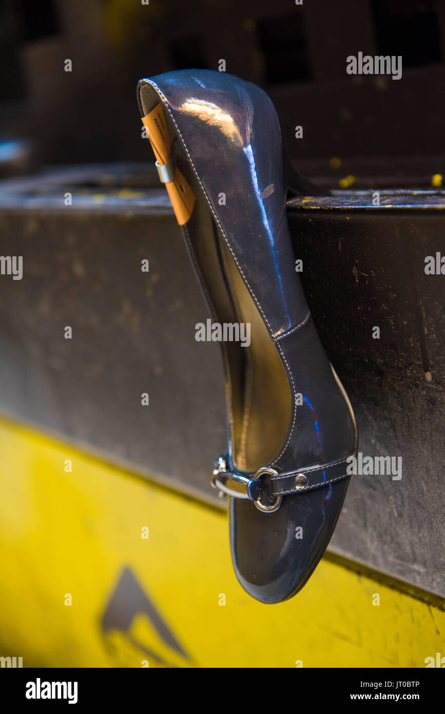 Foto ravvicinate degli attrezzi per la riparazione delle scarpe e delle calzature in un'officina tradizionale di ciabattine, mettendo in evidenza le suole, le attrezzature per la riparazione e il processo di risolina Foto Stock