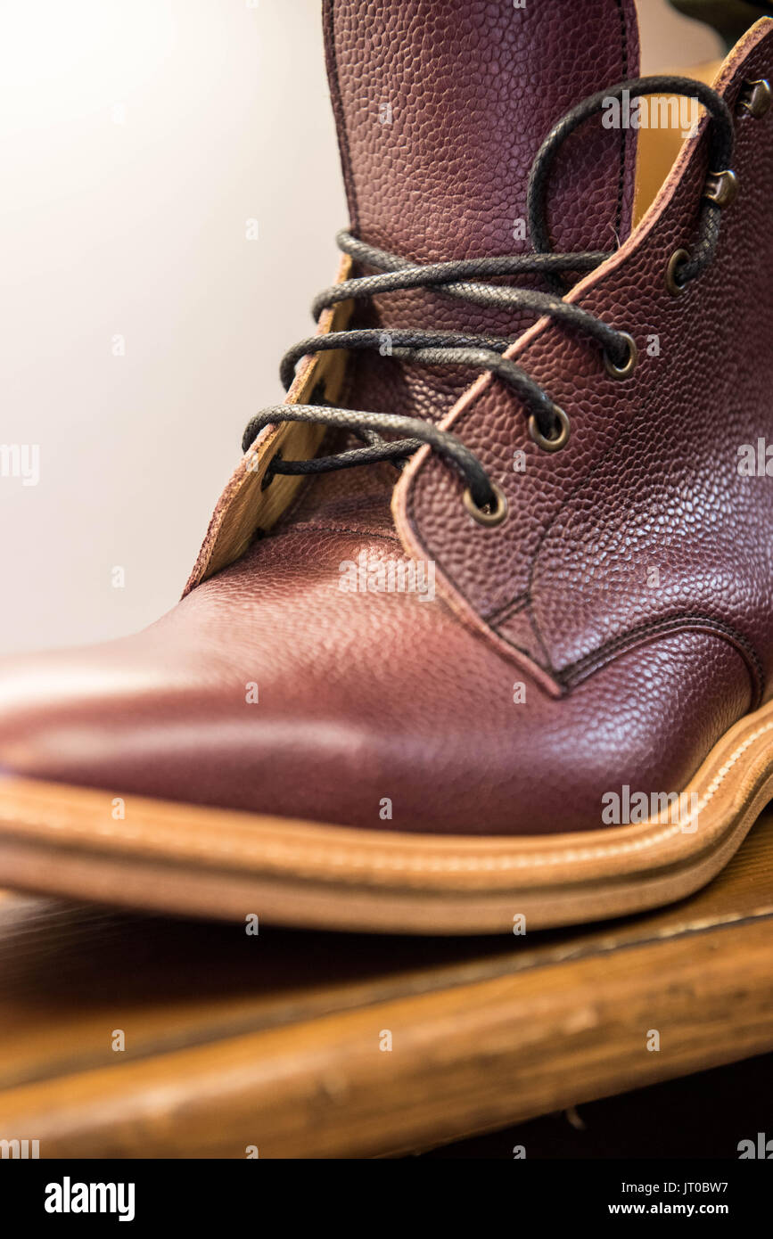 Foto ravvicinate degli attrezzi per la riparazione delle scarpe e delle calzature in un'officina tradizionale di ciabattine, mettendo in evidenza le suole, le attrezzature per la riparazione e il processo di risolina Foto Stock