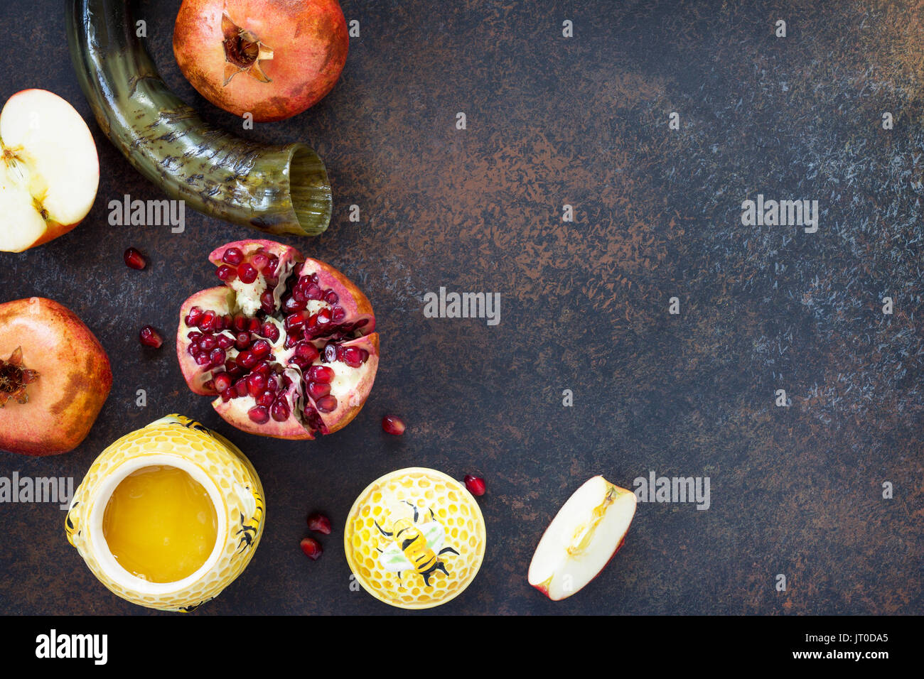 Il concetto di Rosh hashanah (ebreo Nuovo anno). Vacanze tradizionali simboli - shofar, miele, apple e melograno su una pietra o ardesia sfondo. Fla Foto Stock