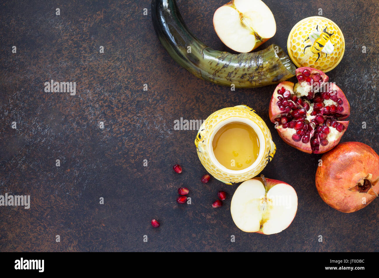 Il concetto di Rosh hashanah (ebreo Nuovo anno). Vacanze tradizionali simboli - shofar, miele, apple e melograno su una pietra o ardesia sfondo. Fla Foto Stock