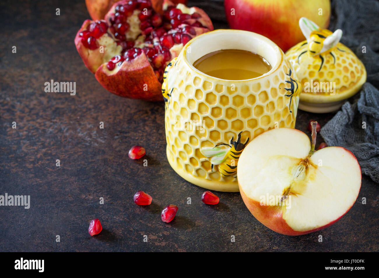 Il concetto di Rosh hashanah (ebreo Nuovo anno). Vacanze tradizionali simboli sono shofar, miele, apple e melograno su una pietra o ardesia tabella. Foto Stock