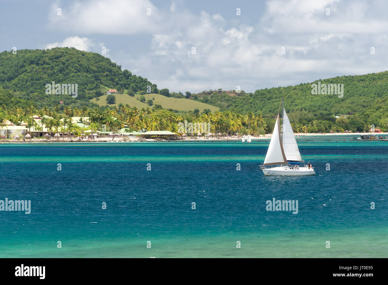 Barca a vela vela sul Baie du Marin, Martinica, Caraibi, e il Club Med Resort in background Foto Stock
