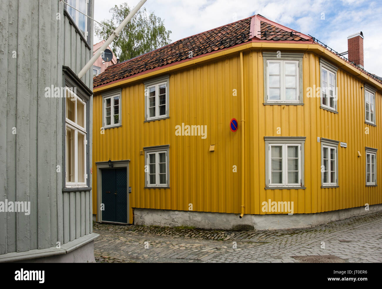 Tradizionale casa in legno con angolo inclinato su una stretta strada di ciottoli nel centro storico. Trondheim, Sør-Trøndelag, Norvegia, Scandinavia, Europa Foto Stock