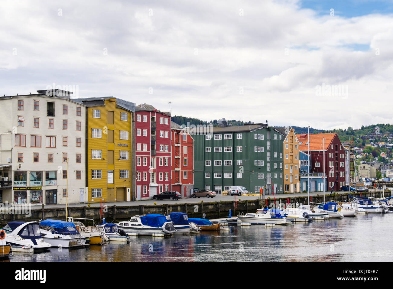Colorata vecchi magazzini di legno e ormeggiate barche da diporto sul fiume Nidelva. Fjorgata, Trondheim, Sør-Trøndelag, Norvegia, Scandinavia, Europa Foto Stock