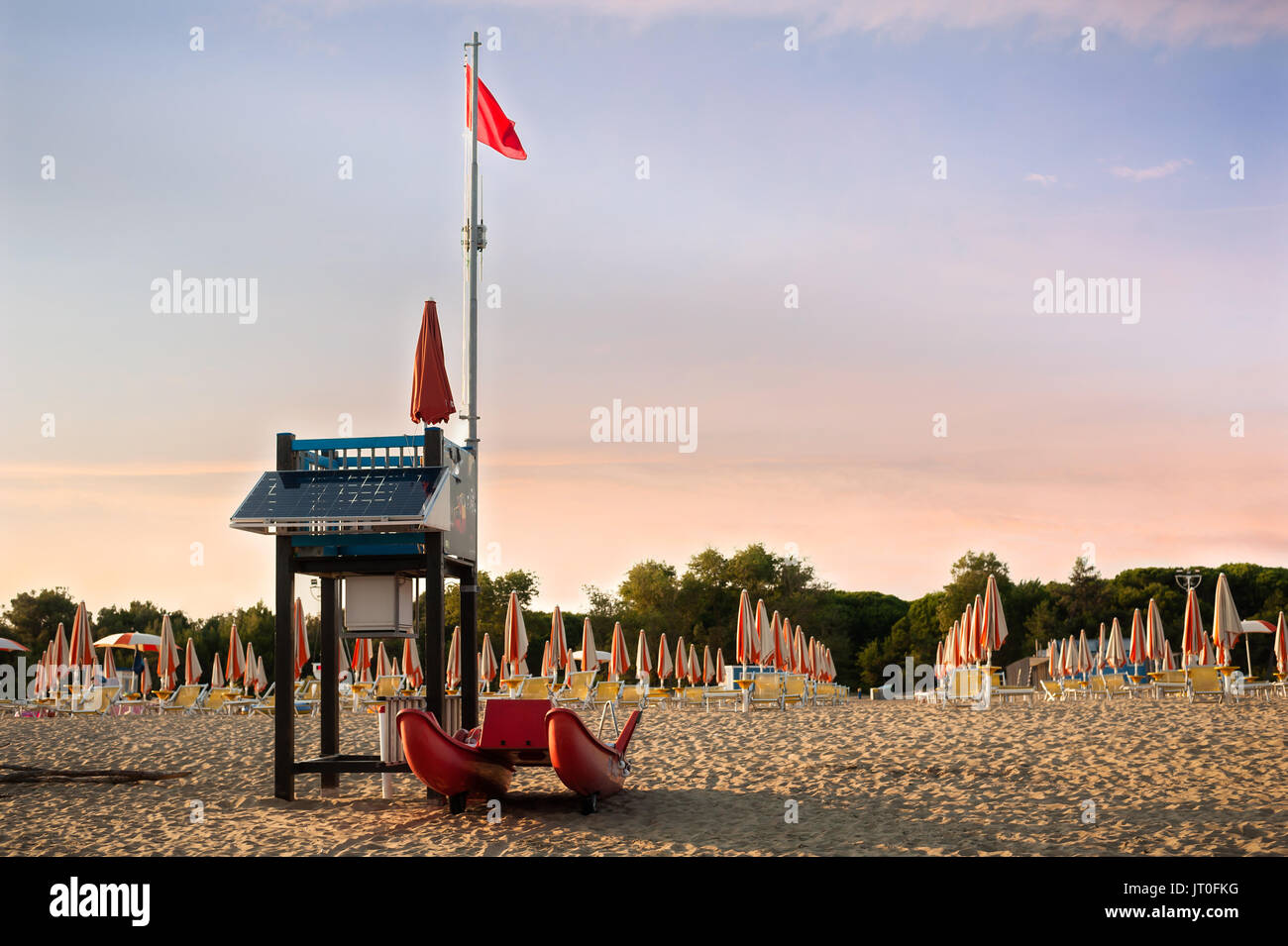 Lifeguard tower su una spiaggia con barca di salvataggio al tramonto. Foto Stock