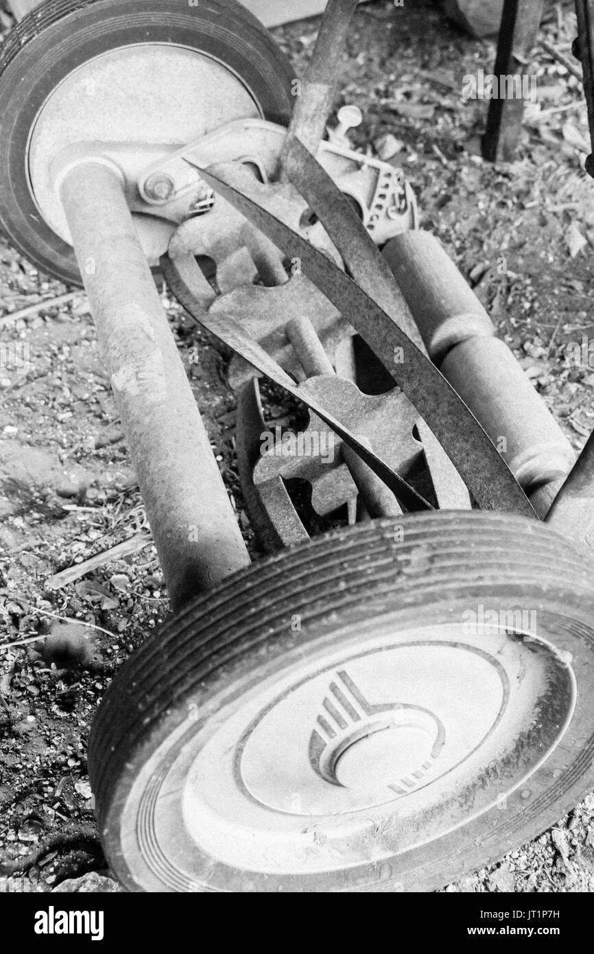 Primo piano di un tosaerba con aspo, mostrando un andamento a spirale del weathered, arrugginito, lame incurvate. Foto Stock