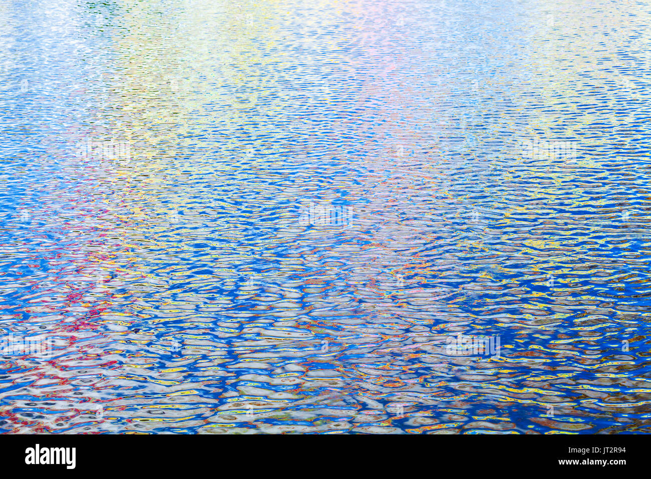 Riflessi colorati pattern su ondulazione superficie dell'acqua. Abstract foto di sfondo Foto Stock
