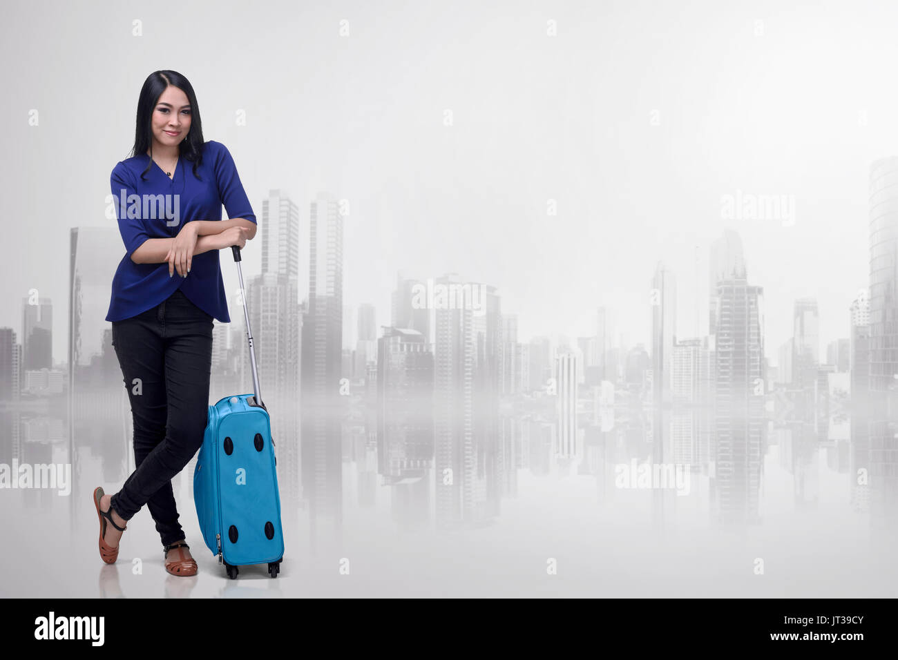 Bella asiatica azienda turistica una valigia maniglia contro sfondo futuristico Foto Stock