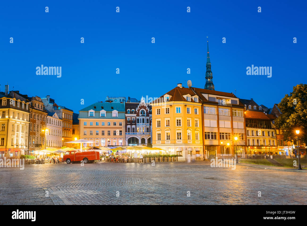 Riga, Lettonia. Vista di antichi edifici architettonici della città vecchia in Piazza Duomo in brillante illuminazione serale, popolare Showplace turistica con Outd Foto Stock
