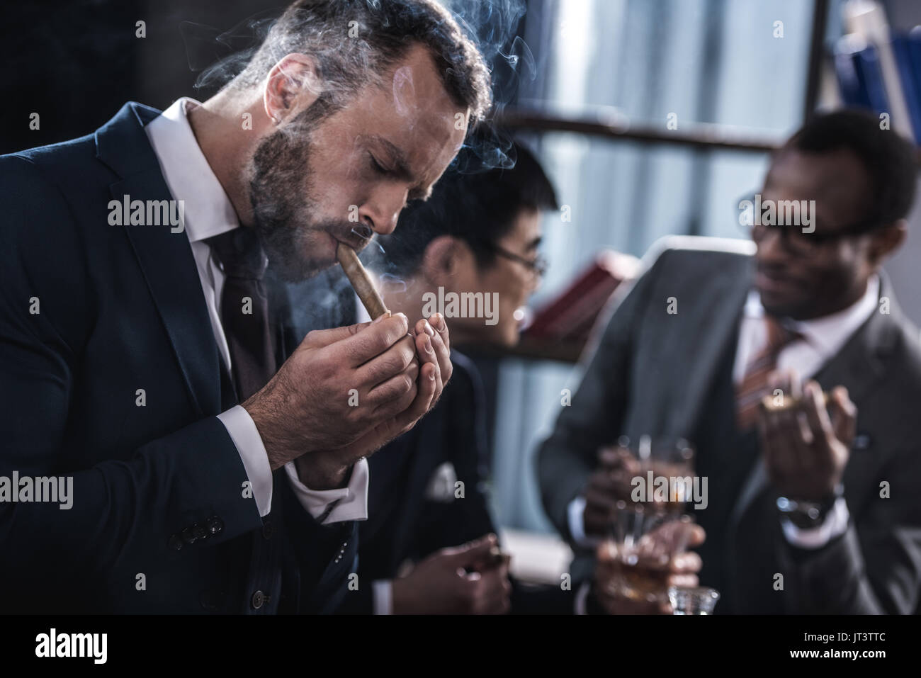 Imprenditore fumatori di sigaro multiculturale con il team Aziende di trascorrere del tempo dietro Foto Stock