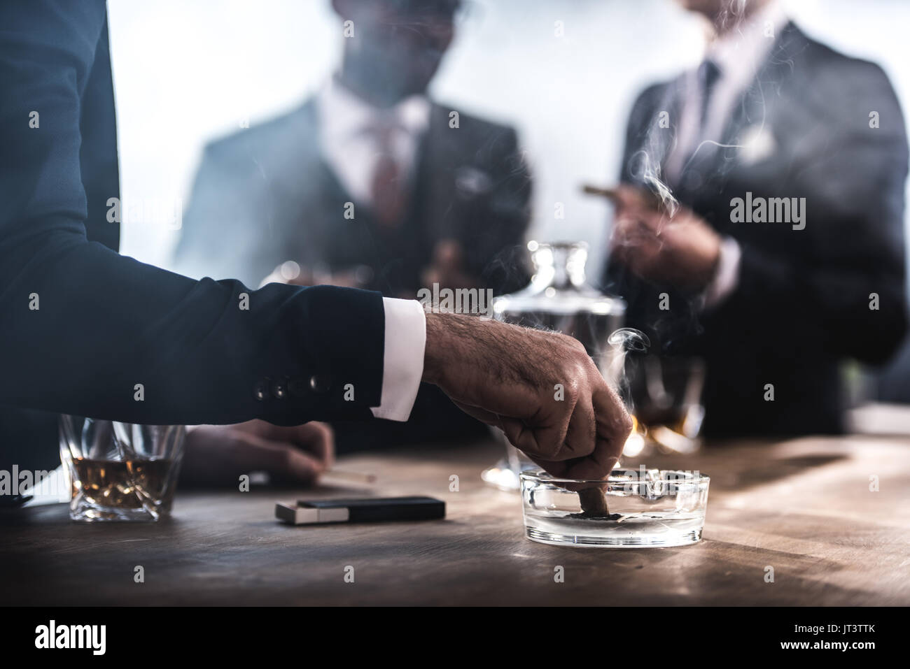 Vista ritagliata di imprenditore di estinzione in sigari Posacenere in vetro Foto Stock