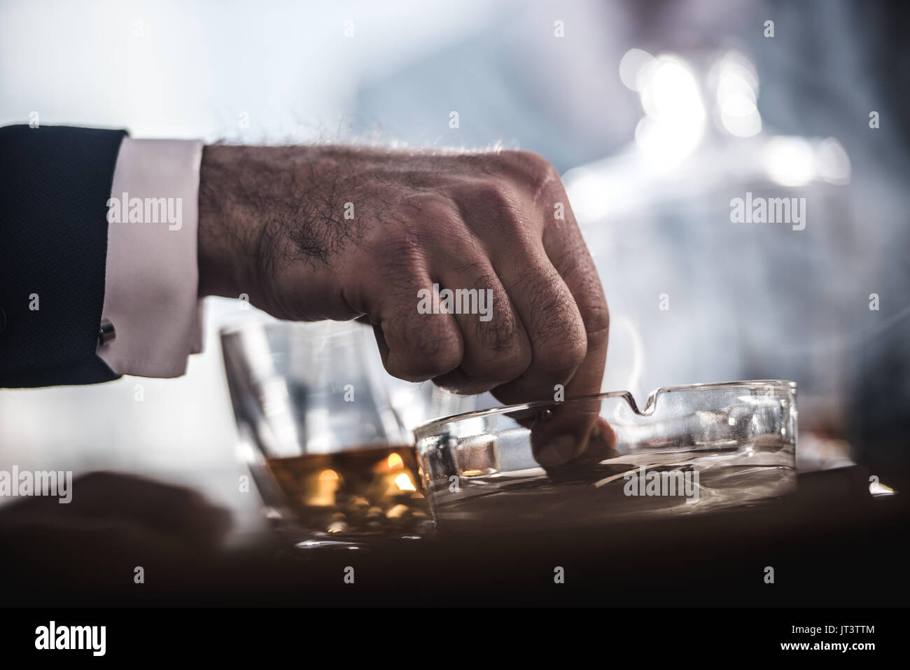 Vista ritagliata di imprenditore di estinzione in sigari Posacenere in vetro Foto Stock