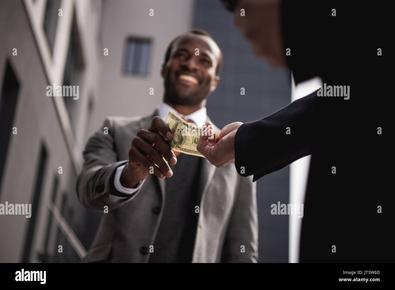 I giovani africani imprenditore americano nel convenzionale prendendo soldi all'aperto Foto Stock