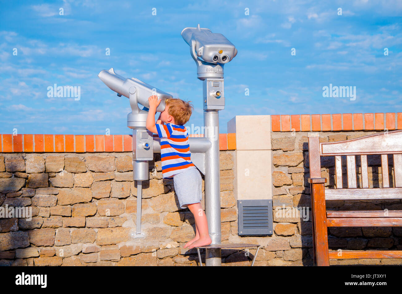 Bambino guarda attraverso il telescopio sulla giornata di sole in estate, vacanze scena Foto Stock