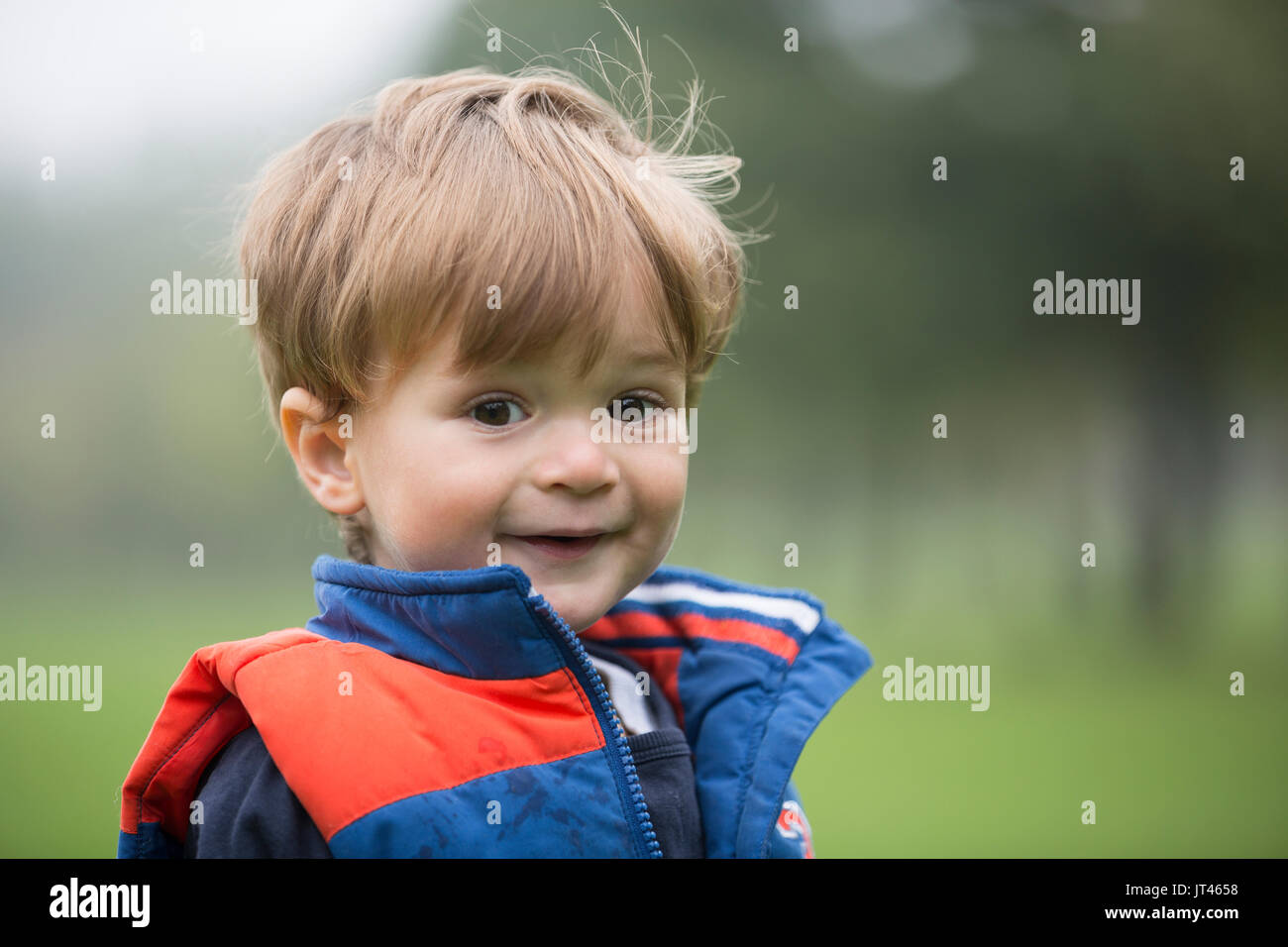 Ritratto di un felice giovane ragazzo all'esterno. Foto Stock