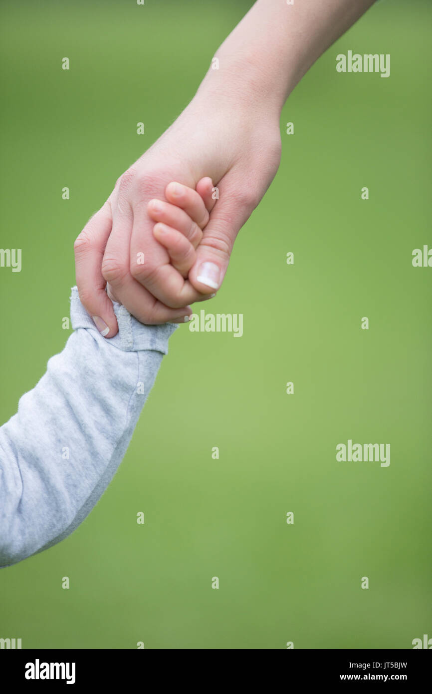 Close up di madre e figlio tenendo le mani all'esterno. La paternità, amore e stare insieme concetto. Foto Stock Close up di madre e figlio tenendo le mani all'esterno. La paternità, amore e stare insieme concetto. Foto Stock