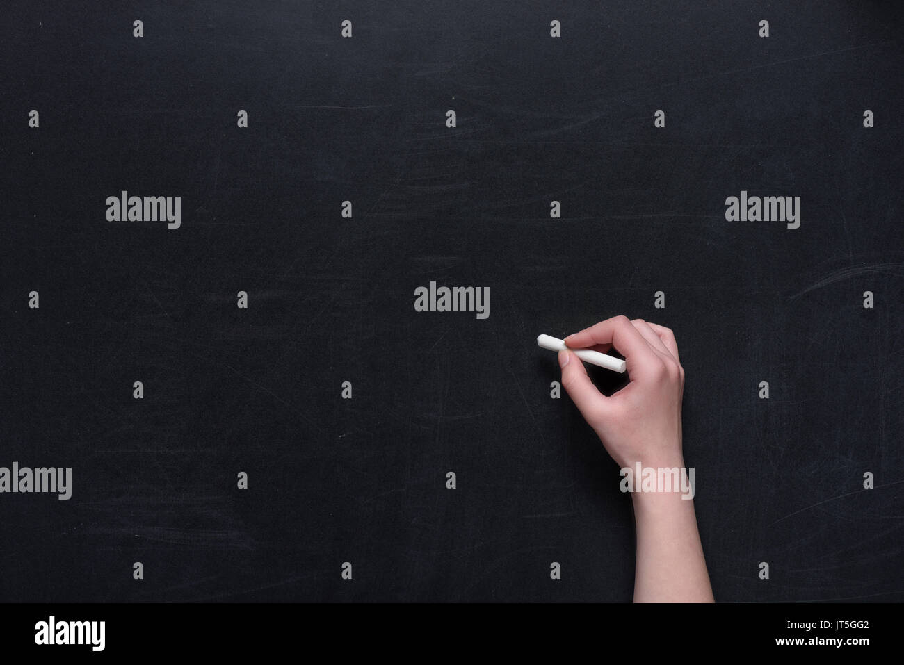 Mano umana la scrittura con un pezzo di gesso sulla lavagna Foto Stock