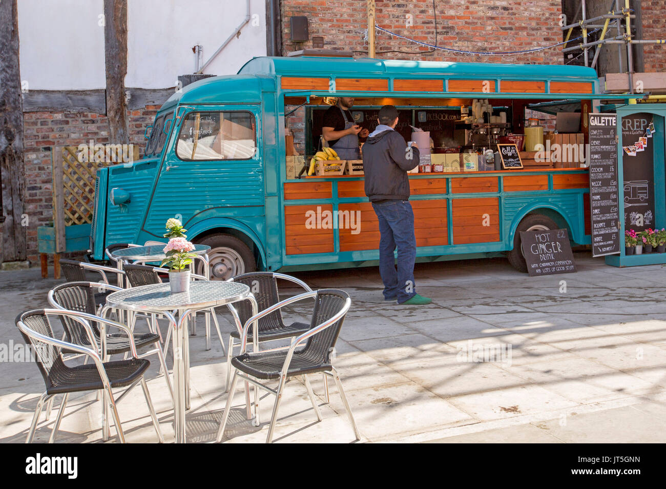 Colorato caffè mobile van, classic Citroen H van, con tavolo e sedie e cliente al contatore essendo servita Foto Stock