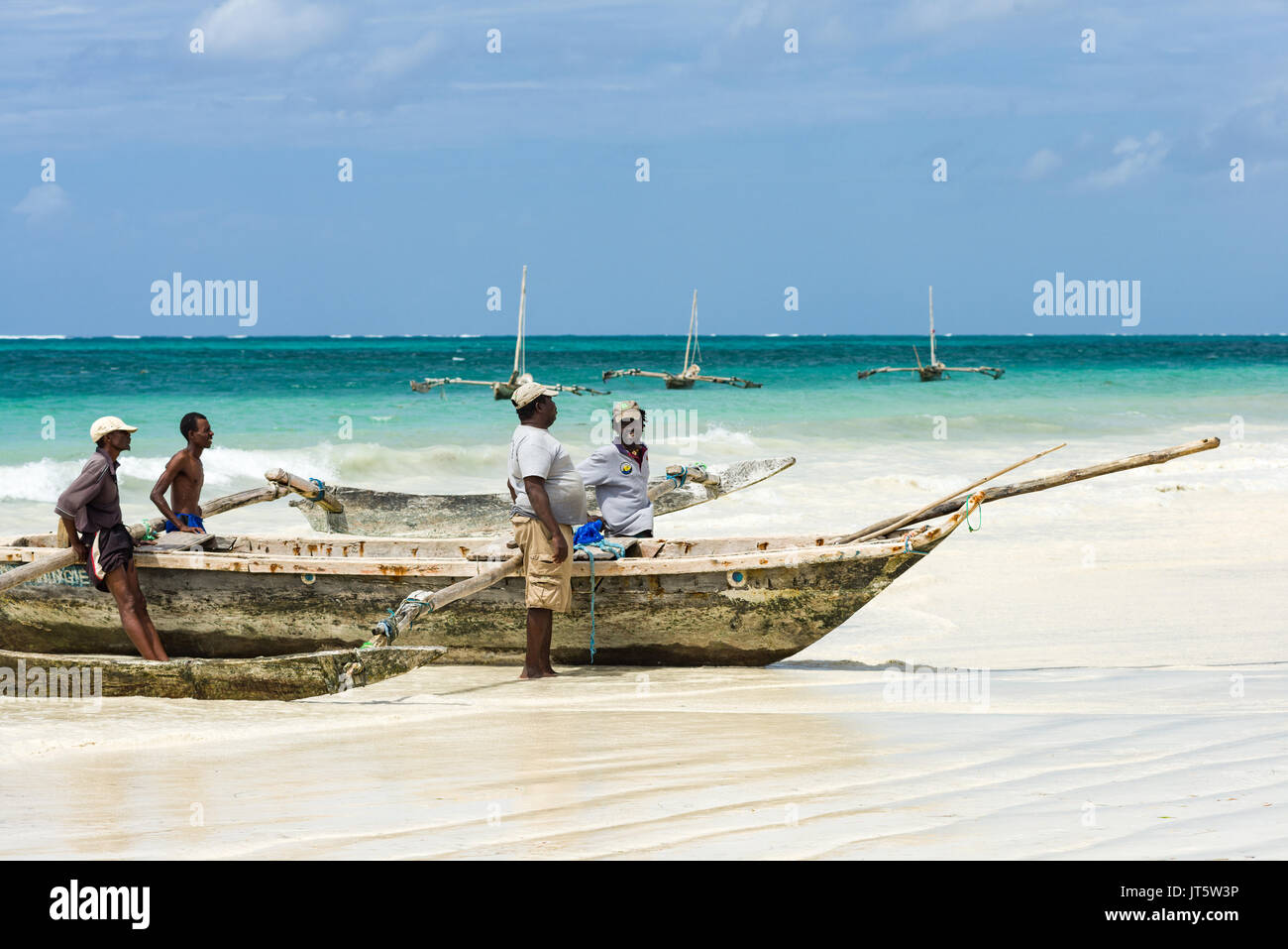 Fisherman attendere per spingere il sambuco tradizionale barca da pesca per l'oceano, la spiaggia di Diani, Kenya Foto Stock