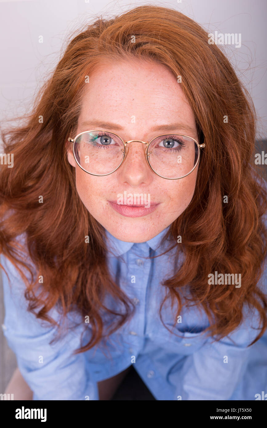 Ritratto di bella i capelli rossi donna con bicchieri da sopra Foto Stock
