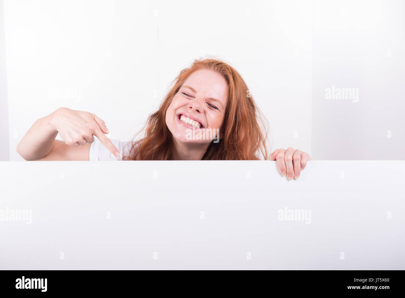 Bellissimi i capelli rossi donna detiene una lavagna bianca Foto Stock