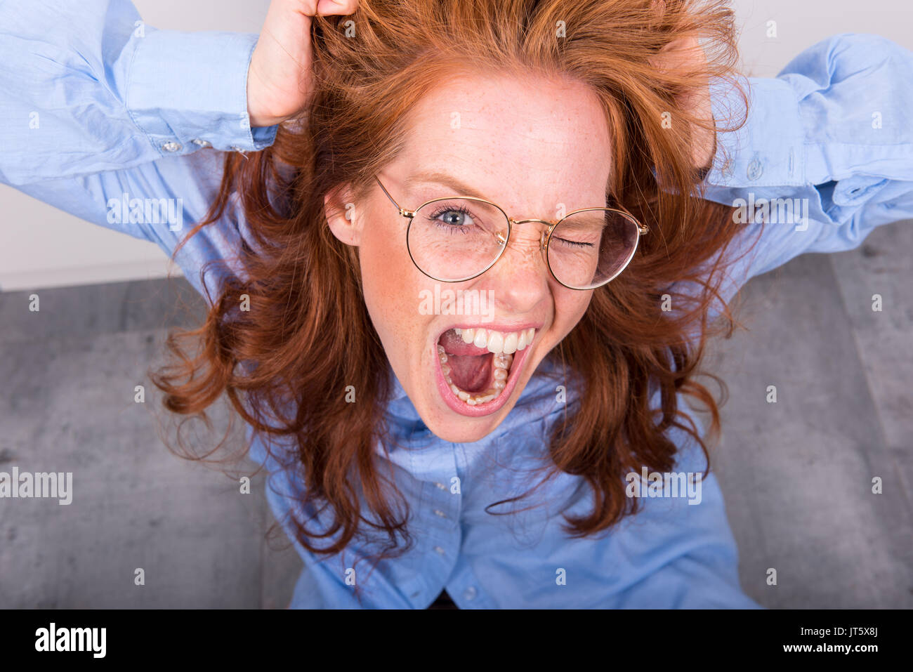 Ritratto di bella i capelli rossi donna con bicchieri da sopra Foto Stock