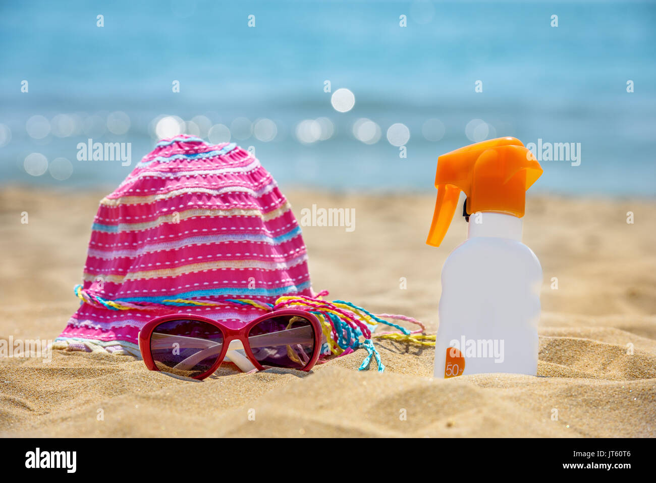 Bottiglia di crema di protezione solare sulla spiaggia sabbiosa. Foto Stock
