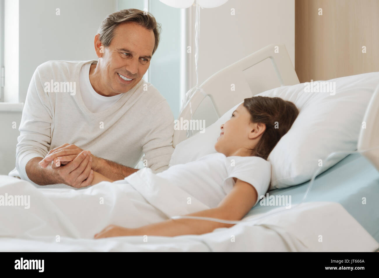 Gioioso padre positivo sorridendo a sua figlia Foto Stock