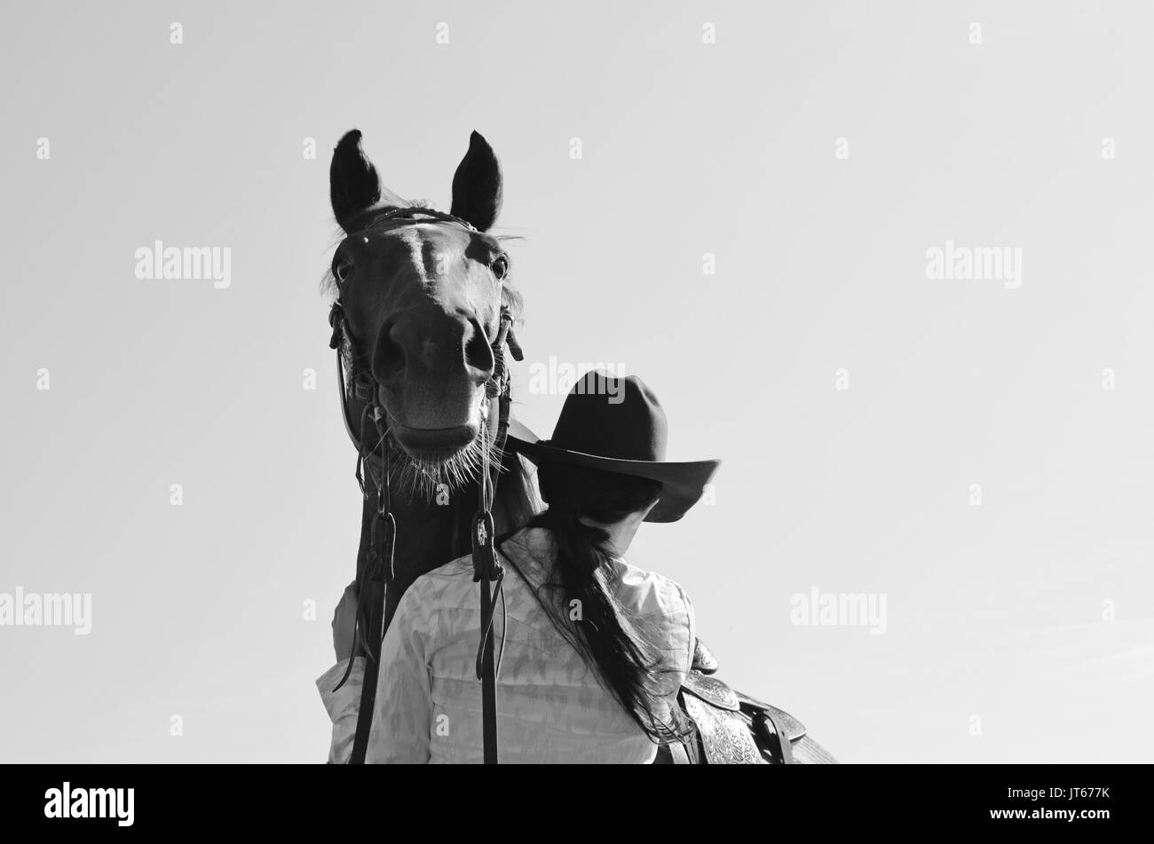 Country Girl nel cappello da cowboy con cavallo carino guardando sopra la sua spalla, western ranch immagine per rappresentare la rustica cowgirl lifestyle. Grande per la stampa. Foto Stock