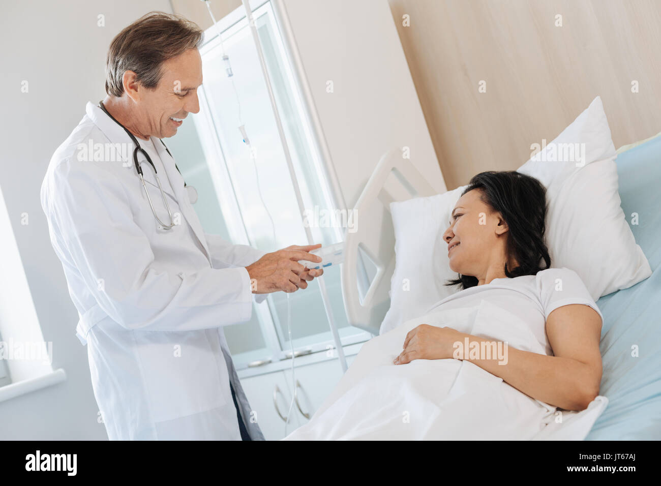 Nizza allegro medico mostrando la medicina per il suo paziente Foto Stock