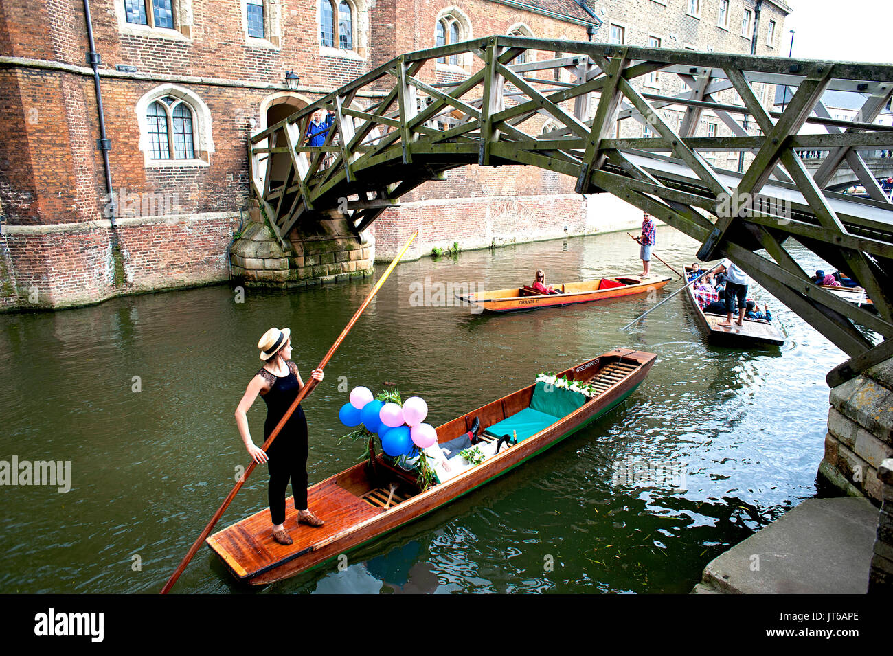 Gli sposi prendere un fiume punt di Cambridge passando sotto il famoso ponte di matematica presso la Queen's College, parte dell'Università di Cambridge. Foto Stock