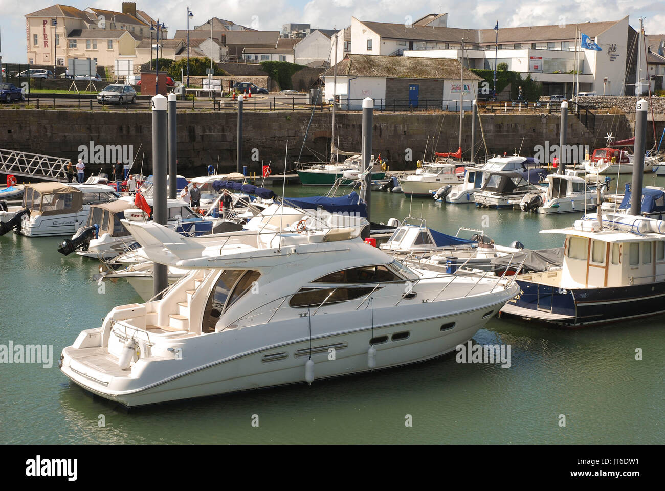 Yacht e Barche galleggiante nella città del porto in Porthcawl, Galles, con una visita a motor cruiser in primo piano Foto Stock