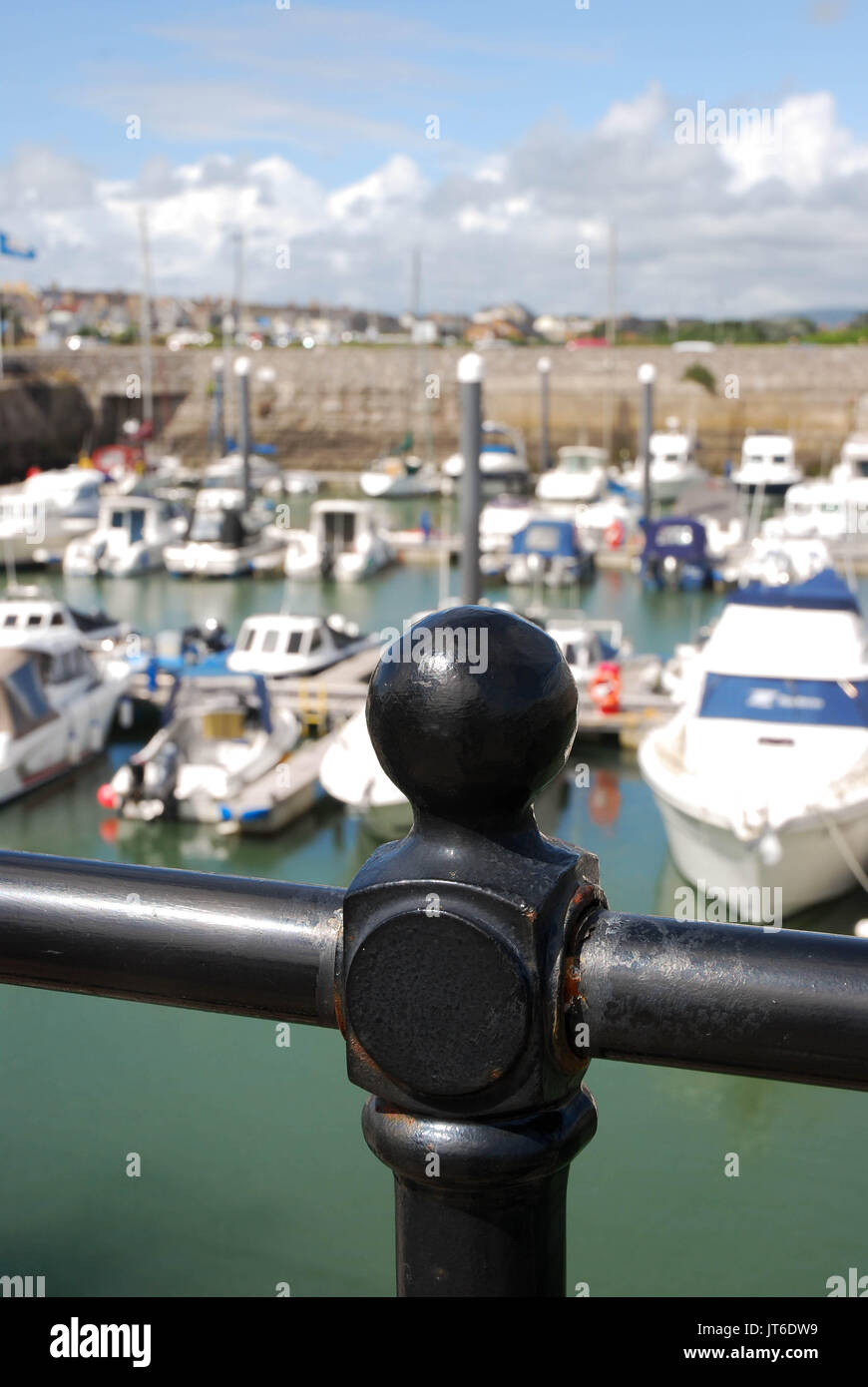 Ravvicinata di una ringhiera di sicurezza che circondano il porto in Porthcawl, Galles con yacht e barche in background Foto Stock