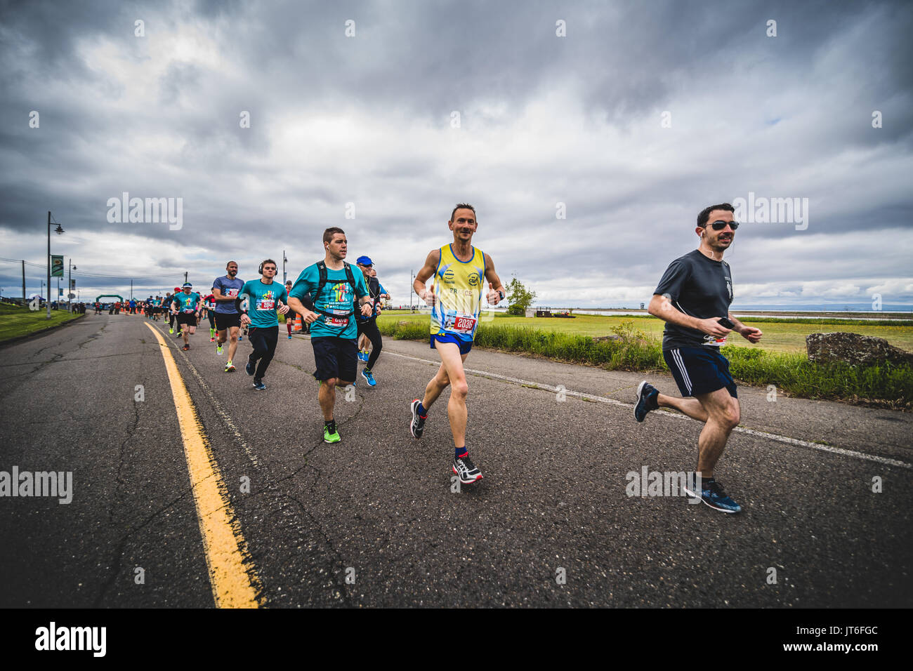 CARLETON, Canada - 4 giugno 2017. Durante la quinta maratona di Carleton in Quebec, Canada. Gruppo di Marathoners subito dopo la linea di partenza Foto Stock